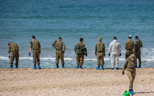 Des soldats israéliens nettoient le goudron sur la plage de Palmachim à la suite d'une marée noire en mer, qui a recouvert la plus grande partie du littoral israélien, le 22 février 2021. (Yonatan Sindel/Flash90 *** Local Caption) Des soldats israéliens nettoient le goudron sur la plage de Palmachim à la suite d'une marée noire en mer, qui a recouvert la plus grande partie du littoral israélien, le 22 février 2021. (Yonatan Sindel/Flash90 *** Local Caption)
