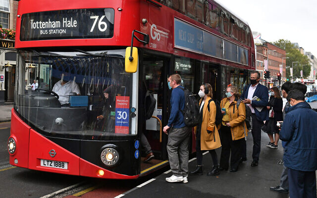 Photo d'illustration : Des londoniens montent à bord d'un bus aux abords de la gare de Waterloo, à Londres, le 23 septembre 2020. (Crédit : Dominic Lipinski/PA via AP) Photo d'illustration : Des londoniens montent à bord d'un bus aux abords de la gare de Waterloo, à Londres, le 23 septembre 2020. (Crédit : Dominic Lipinski/PA via AP)