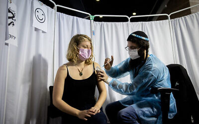 Une Israélienne se fait vacciner contre la  COVID-19 à Jérusalem, le 10 février 2021. (Crédit : Yonatan Sindel/Flash90)