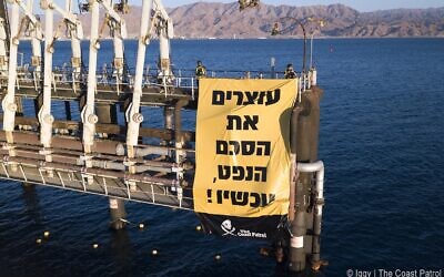 Une manifestation contre l'expansion des activités au port pétrolier de l'entreprise EAPC à Eilat, avec une bannière disant : "Arrêt immédiat de l'accord sur le pétrole," le 10 février 2021. (Crédit : Egor Iggy Petrenko/Coast Patrol)