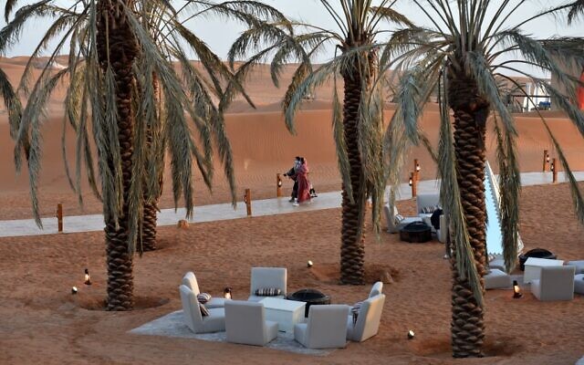 Des visiteurs marchent sous des palmiers à l'"Oasis de Riyad", une retraite de luxe dans le désert de Thumamah, à la périphérie de la capitale saoudienne, le 1er février 2021. (Crédit : FAYEZ NURELDINE / AFP) Des visiteurs marchent sous des palmiers à l'"Oasis de Riyad", une retraite de luxe dans le désert de Thumamah, à la périphérie de la capitale saoudienne, le 1er février 2021. (Crédit : FAYEZ NURELDINE / AFP)