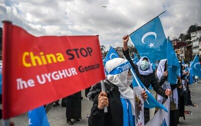 Des membres de la minorité musulmane ouïgoure brandissent des pancartes et des drapeaux du Turkestan oriental alors qu'elles manifestent pour demander des nouvelles de leurs proches et pour exprimer leur inquiétude quant à la ratification d'un traité d'extradition entre la Chine et la Turquie, près du consulat de Chine à Istanbul, le 8 mars 2021, lors de la Journée internationale de la femme. (Crédit : Ozan KOSE / AFP)