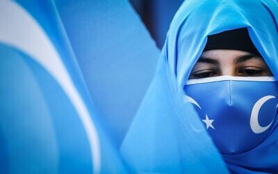 Des membres de la minorité musulmane ouïghoure tiennent des pancartes et des drapeaux du Turkestan oriental alors qu'elles manifestent pour avoir des nouvelles de leurs proches et exprimer leur inquiétude quant à la ratification d'un traité d'extradition entre la Chine et la Turquie, près du consulat de Chine à Istanbul, le 8 mars 2021, lors de la Journée internationale de la femme.  (Crédit : Ozan KOSE / AFP)