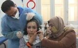 Maram, huit ans, enfile un masque imprimé en 3D développé par Médecins sans frontières, qui lui couvre le visage et traite ses graves brûlures causées par l'incendie d'une boulangerie à Gaza. (Capture d'écran/AFP)