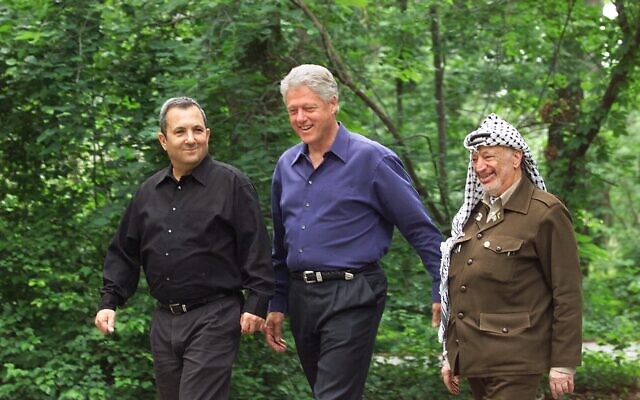 Le président américain de l'époque, Bill Clinton, (au centre), le Premier ministre Ehud Barak (à gauche) et le leader palestinien Yasser Arafat marchent sur le site de Camp David, dans le Maryland, au début du sommet sur le Moyen-Orient, le 11 juillet 2000. (AP Photo/ Ron Edmonds, File) Le président américain de l'époque, Bill Clinton, (au centre), le Premier ministre Ehud Barak (à gauche) et le leader palestinien Yasser Arafat marchent sur le site de Camp David, dans le Maryland, au début du sommet sur le Moyen-Orient, le 11 juillet 2000. (AP Photo/ Ron Edmonds, File)