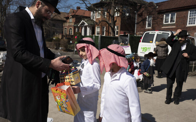 Illustration : des garçons déguisés pour Pourim, dans le quartier de Crown Heights à New York. le 26 février 2021, (Crédit : AP Photo/Mark Lennihan) Illustration : des garçons déguisés pour Pourim, dans le quartier de Crown Heights à New York. le 26 février 2021, (Crédit : AP Photo/Mark Lennihan)
