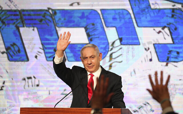 Le Premier ministre Benjamin Netanyahu salue ses partisans après les résultats des sondages de sortie des urnes à l'issue des élections à la Knesset, au siège de son parti à Jérusalem, le 24 mars 2021. (Crédit : AP Photo/Ariel Schalit, file)