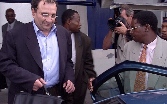 Ari Ben Menashe, un consultant israélo-canadien, est emmené dans une voiture par le personnel de sécurité du Zimbabwe peu après son arrivée à l'aéroport international de Harare, le vendredi 22 février 2002. Ben-Menashe est censé aider la police zimbabwéenne à enquêter sur un présumé complot du leader de l'opposition Morgan Tsvangirai visant à assassiner le président Robert Mugabe. (AP Photo)