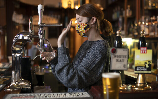 Une barista remplit un verre au pub Dispensary de Liverpool, en Angleterre, le 12 octobre 2020. (AP Photo / Jon Super) Une barista remplit un verre au pub Dispensary de Liverpool, en Angleterre, le 12 octobre 2020. (AP Photo / Jon Super)