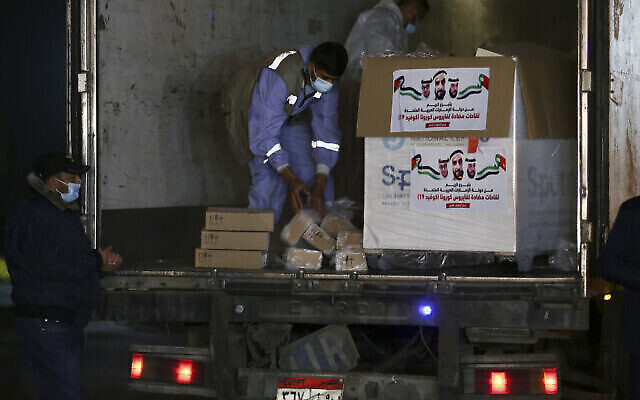 Les agents de police du Hamas montent la garde lors du déchargement d'un camion transportant 40 000 doses de vaccin russe anti-COVID-19 Sputnik V à son arrivée dans la bande de Gaza, au poste-frontière de Rafah avec l'Égypte, le 11 mars 2021. (Crédit : Adel Hana/AP)