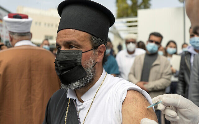 Photo d'illustration : Un prêtre chrétien palestinien se fait vacciner contre la COVID-19 pendant une campagne de vaccination des travailleurs essentiels au ministère de la Santé de Ramallah, en Cisjordanie, le 21 mars 2021. (Crédit : Nasser Nasser/AP) Photo d'illustration : Un prêtre chrétien palestinien se fait vacciner contre la COVID-19 pendant une campagne de vaccination des travailleurs essentiels au ministère de la Santé de Ramallah, en Cisjordanie, le 21 mars 2021. (Crédit : Nasser Nasser/AP)