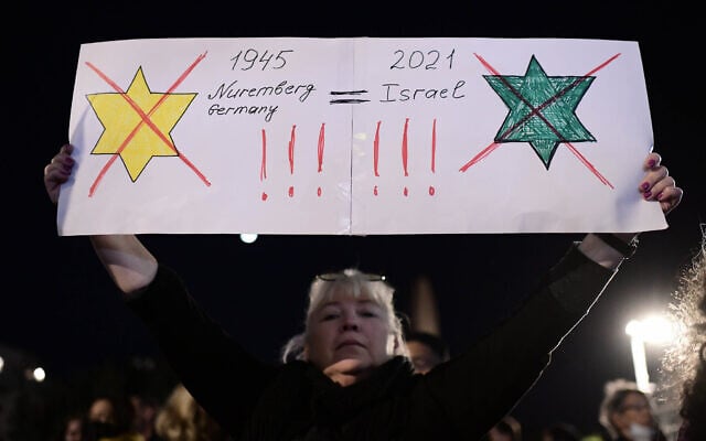 Une manifestante compare apparemment le certificat de vaccination vert d'Israël aux lois nazies obligeant les Juifs à porter l'étoile jaune à Tel Aviv, le 15 février 2021. (Tomer Neuberg/FLASH90) Une manifestante compare apparemment le certificat de vaccination vert d'Israël aux lois nazies obligeant les Juifs à porter l'étoile jaune à Tel Aviv, le 15 février 2021. (Tomer Neuberg/FLASH90)
