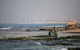 Des soldats nettoient le goudron sur la plage de Palmachim suite à une marée noire en mer, qui a recouvert la majeure partie des côtes israéliennes, le 22 février 2021. (Yonatan Sindel/Flash90)