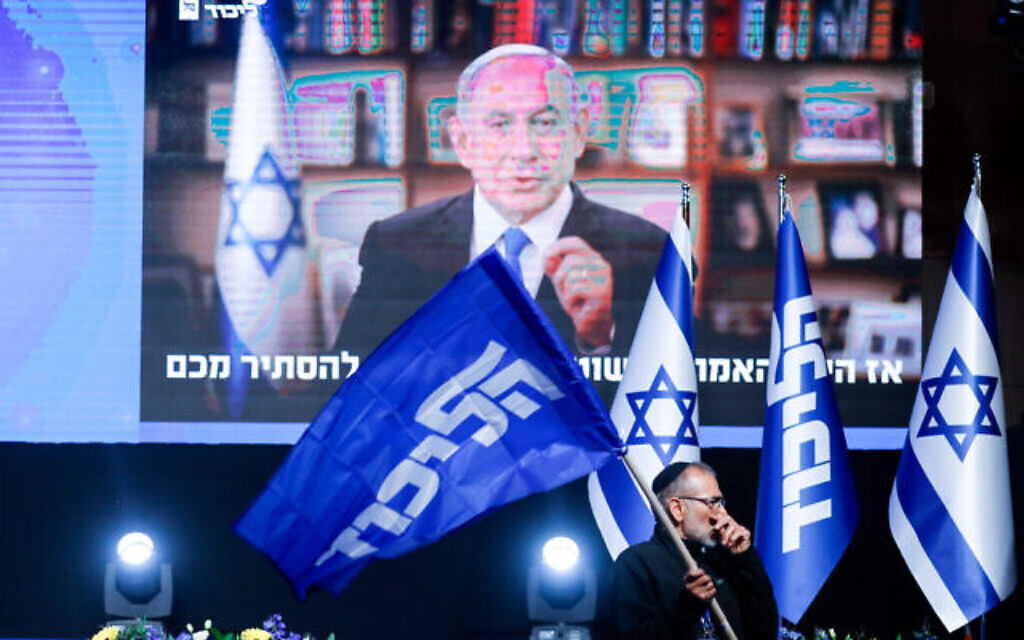 Un partisan du Likud devant une vidéo de Benjamin Netanyahu lors d'un événement du parti à Jérusalem, le 23 mars 2021. (Crédit : Olivier Fitoussi/Flash90)
