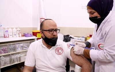 Des Palestiniens se font vacciner contre la  COVID-19 dans la ville de Hébron, en Cisjordanie, le 25 mars 2021. (Crédit :  Wisam Hashlamoun/Flash90)