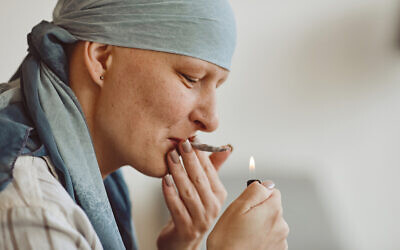 Une femme fume de la marijuana à des fins médicinales dans le cadre d'un traitement contre le cancer (Crédit : SeventyFour via iStock by Getty Images)