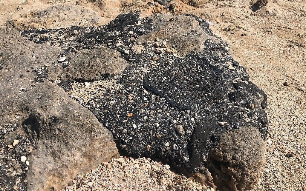Du goudron sur les rochers sur la plage d'Achziv, le 25 février 2021. (Crédit : Sue Surkes/Times of Israel)