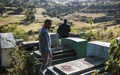 Sitotaw Alene (à droite) et Adamu Mengistu, dirigeants de la communauté juive éthiopienne, visitent le cimetière de la communauté à la périphérie de la ville de Gondar, en Ethiopie, le 26 octobre 2020. (Crédit : EDUARDO SOTERAS / AFP)