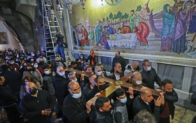 Des fidèles chrétiens portant une croix de bois arrivent à l'église du Saint-Sépulcre, lors de la procession du Vendredi Saint le long de la Via Dolorosa dans la Vieille Ville de Jérusalem, le 2 avril 2021. (Emmanuel DUNAND / AFP)