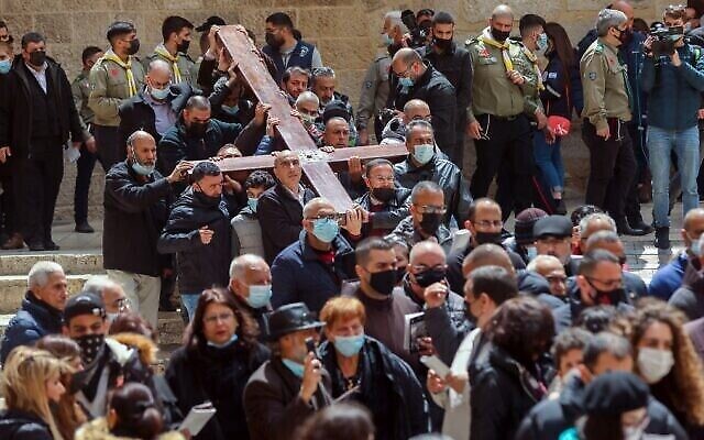 Des fidèles chrétiens portant une croix de bois arrivent à l'église du Saint-Sépulcre, lors de la procession du Vendredi Saint le long de la Via Dolorosa dans la Vieille Ville de Jérusalem, le 2 avril 2021. (Emmanuel DUNAND / AFP)
