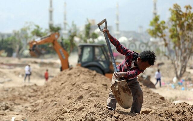 Un ouvrier yéménite aide en tant qu'excavateur à creuser des tombes pour les victimes de la COVID-19 dans un cimetière de Taez, troisième ville du Yémen, le 3 avril 2021. (Crédit : AHMAD AL-BASHA / AFP) Un ouvrier yéménite aide en tant qu'excavateur à creuser des tombes pour les victimes de la COVID-19 dans un cimetière de Taez, troisième ville du Yémen, le 3 avril 2021. (Crédit : AHMAD AL-BASHA / AFP)