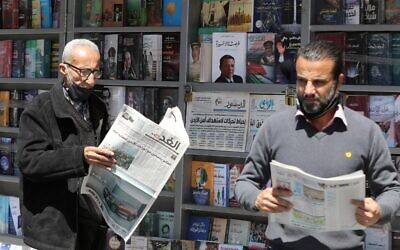 Des hommes jordaniens lisent des journaux locaux avec des titres en première page sur les derniers événements dans leur pays, devant un kiosque dans la capitale Amman, le 4 avril 2021. Les médias officiels jordaniens ont prévenu aujourd'hui que la sécurité et la stabilité constituaient une "ligne rouge", au lendemain de l'arrestation de plusieurs personnalités et de la mise en résidence surveillée d'un demi-frère du roi Abdallah II. (Khalil MAZRAAWI / AFP)