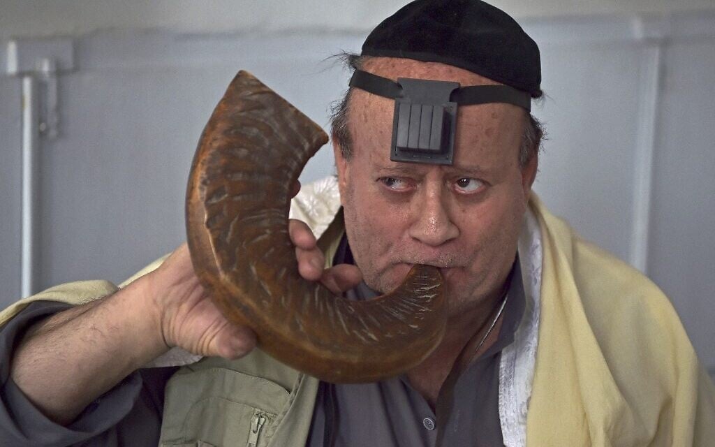 Zebulon Simentov, Juif afghan, sonne le chofar dans une synagogue située dans un ancien bâtiment de Kaboul, le 5 avril 2021. (Crédit : WAKIL KOHSAR / AFP)