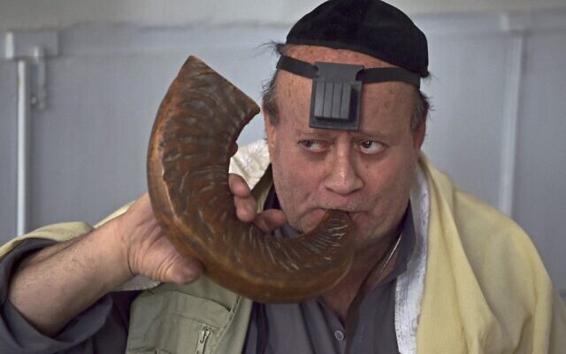 Zebulon Simentov, Juif afghan, sonne le chofar dans une synagogue située dans un ancien bâtiment de Kaboul, le 5 avril 2021. (Crédit : WAKIL KOHSAR / AFP)