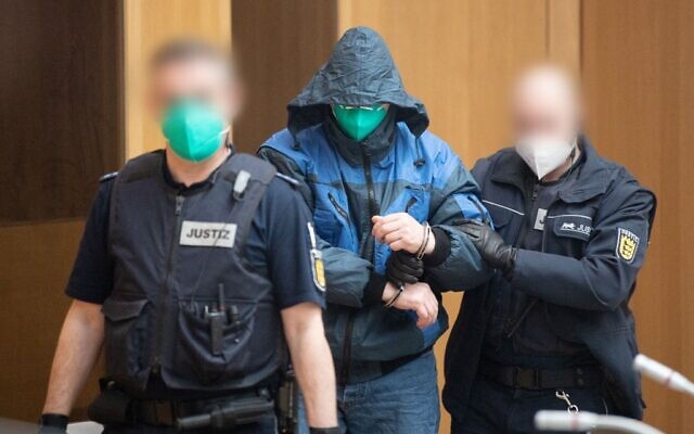 Un accusé est escorté par des officiers de justice pour l'ouverture d'un procès contre douze hommes accusés d'avoir créé et soutenu une organisation terroriste, le "Groupe S" (Gruppe S.), le 13 avril 2021 au tribunal de Stuttgart - Stammheim, dans le sud de l'Allemagne. Le groupe, qui porte le nom de son chef Werner S., est soupçonné d'avoir planifié des attaques contre des mosquées et des hommes politiques. (POOL / AFP)