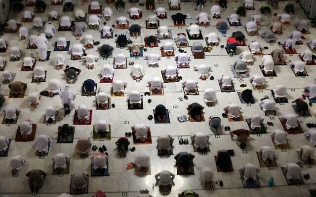 Des fidèles musulmans effectuent la prière de Tarawih pendant le mois de jeûne du Ramadan autour de la Kaaba dans le complexe de la Grande Mosquée de la ville sainte de La Mecque, le 13 avril 2021. (Crédit : AFP) Des fidèles musulmans effectuent la prière de Tarawih pendant le mois de jeûne du Ramadan autour de la Kaaba dans le complexe de la Grande Mosquée de la ville sainte de La Mecque, le 13 avril 2021. (Crédit : AFP)