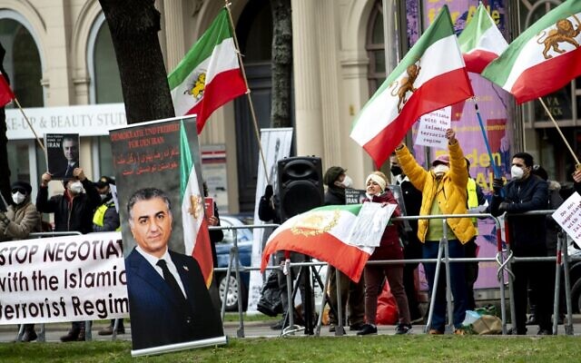 Des membres du Conseil national de la résistance iranienne, un groupe d'opposition iranien, manifestent devant le Grand Hôtel Wien, où se déroulent les négociations nucléaires à huis clos avec l'Iran, à Vienne, le 15 avril 2021. Les diplomates de l'UE, de la Chine, de la Russie et de l'Iran y tiennent leurs discussions. (Crédit : JOE KLAMAR / AFP)