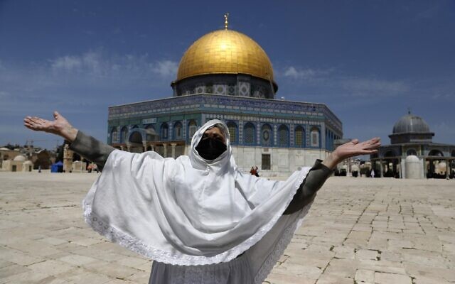 Une femme palestinienne lève les bras pour la première lors de la première prière du vendredi du Ramadan aux abords du Dôme des roches, sur le mont du Temple de Jérusalem, le 26 avril 2021. (Crédit : Ahmad GHARABLI / AFP) Une femme palestinienne lève les bras pour la première lors de la première prière du vendredi du Ramadan aux abords du Dôme des roches, sur le mont du Temple de Jérusalem, le 26 avril 2021. (Crédit : Ahmad GHARABLI / AFP)