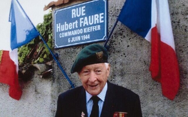 Hubert Faure, ancien membre des commandos Kieffer, groupe de 177 soldats français ayant participé à l'invasion de la Normandie connue sous le nom d'Opération Overlord pendant la Seconde Guerre mondiale, devant une plaque de rue portant son nom à Neuvic-sur-Isle, en 2008. (Crédit : AFP)
