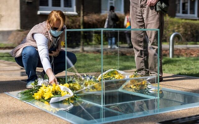 Ds Polonais déposent une gerbe et des fleurs devant un monument dédié aux archives souterraines du ghetto juif de Varsovie, lors de son inauguration sur le site où les archives Ringelblum ont été cachées pendant l'occupation nazie pendant la Seconde Guerre mondiale, à Varsovie, le 19 avril, 2021 (Crédit : Wojtek RADWANSKI / AFP) Ds Polonais déposent une gerbe et des fleurs devant un monument dédié aux archives souterraines du ghetto juif de Varsovie, lors de son inauguration sur le site où les archives Ringelblum ont été cachées pendant l'occupation nazie pendant la Seconde Guerre mondiale, à Varsovie, le 19 avril, 2021 (Crédit : Wojtek RADWANSKI / AFP)