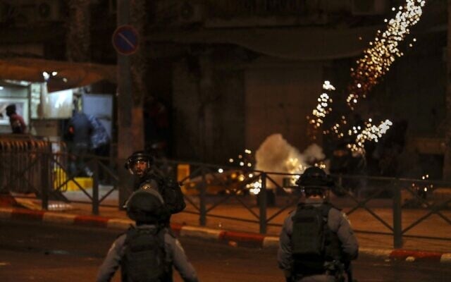 Des Palestiniens fuient les grenades incapacitantes des forces de sécurité israéliennes dans un cadre d'affrontements entre des Juifs d'extrême-droite et des contre-manifestants arabes dans la Vieille Ville de Jérusalem, le 22 avril 2021. (Crédit :  AHMAD GHARABLI / AFP)