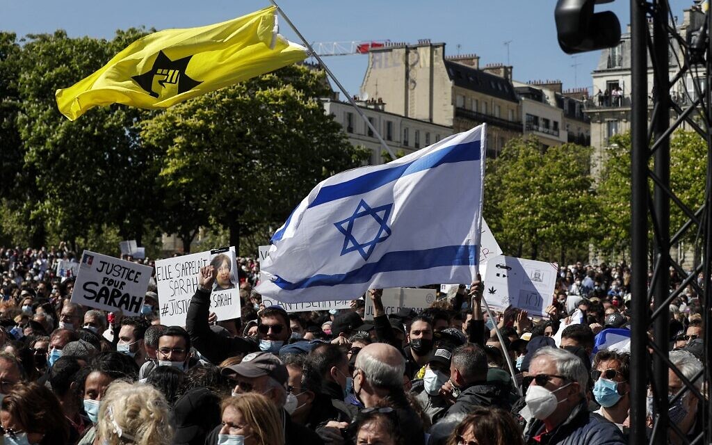 Un homme brandit un drapeau d'Israël à côté d'un drapeau de la Ligue de défense juive au rassemblement pour demander justice pour Sarah Halimi, sur la place du Trocadéro, devant la tour Eiffel, à Paris, le 25 avril 2021. (Crédit : GEOFFROY VAN DER HASSELT / AFP)
