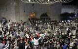 Des manifestants palestiniens brandissent des drapeaux nationaux durant un rassemblement près de la porte de Damas dans la vieille ville de Jérusalem, le 25 avril 2021. (Crédit : Ahmad GHARABLI / AFP)