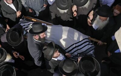 Des hommes juifs ultra-orthodoxes participent à une cérémonie funéraire à Jérusalem pour la victime d'un mouvement de foule meurtrier la nuit précédente lors du rassemblement de Lag B’Omer dans le nord d'Israël, le 30 avril 2021. (Crédit : Menahem KAHANA / AFP)