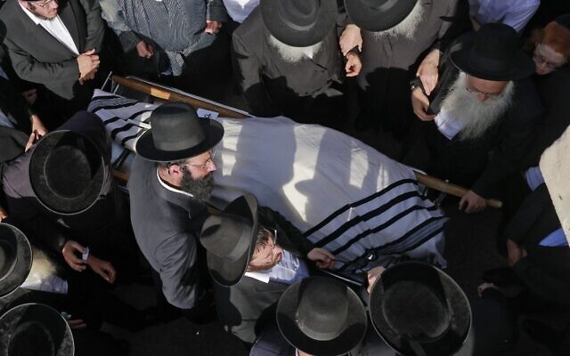Des hommes juifs ultra-orthodoxes participent à une cérémonie funéraire à Jérusalem pour la victime d'un mouvement de foule meurtrier la nuit précédente lors du rassemblement de Lag B’Omer dans le nord d'Israël, le 30 avril 2021. (Crédit : Menahem KAHANA / AFP)