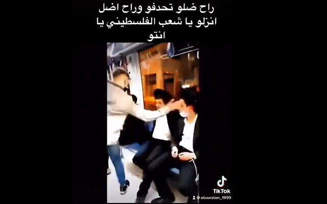 Une vidéo publiée sur TikTok montre un suspect de Jérusalem-Est en train de gifler deux jeunes juifs ultra-orthodoxes dans le tramway de la ville, le 15 avril 2021. (Capture d'écran vidéo) Une vidéo publiée sur TikTok montre un suspect de Jérusalem-Est en train de gifler deux jeunes juifs ultra-orthodoxes dans le tramway de la ville, le 15 avril 2021. (Capture d'écran vidéo)