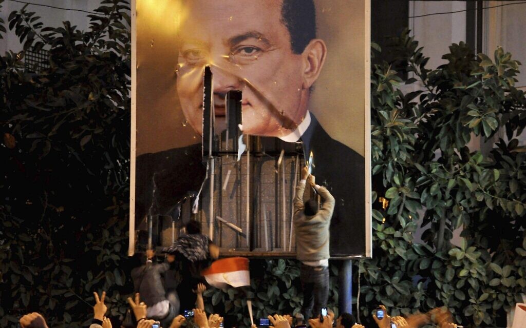 Des manifestants dégradent une affiche du président égyptien Hosni Moubarak à Alexandrie, en Égypte, le 25 janvier 2011. (Crédit : AP) Des manifestants dégradent une affiche du président égyptien Hosni Moubarak à Alexandrie, en Égypte, le 25 janvier 2011. (Crédit : AP)
