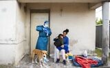 Un employé se prépare à effectuer un test de dépistage au coronavirus sur un enfant dans une banlieue de Montevideo, en  Uruguay, le 18 mars 2021. (Crédit : AP Photo/Matilde Campodonico)