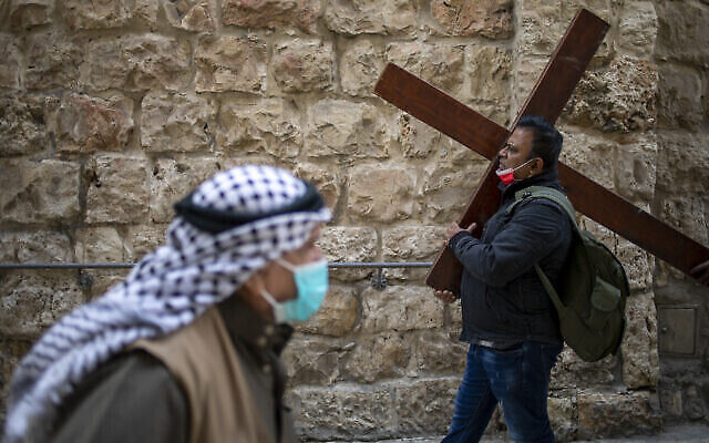 Un Chrétien marche sur la Voie Dolorosa vers l'Église du Saint Sépulcre, considérée comme le site de la crucifixion du Christ, à la procession du vendredi saint dans la Vieille Ville de Jérusalem le 2 avril 2021. (AP Photo / Ariel Schalit)