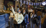 Des femmes israéliennes fêtent Yom HaAtsmaout au marché Mahane Yehuda à Jérusalem, après plus d'un an de restrictions liées au coronavirus, le 14 avril 2021. (Crédit : AP Photo/Maya Alleruzzo)
