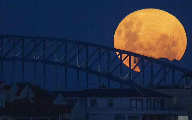 La super lune rose au dessus du Sydney Harbour Bridge en Australie, le 27 avril 2021. (Crédit : AP Photo/Mark Baker) La super lune rose au dessus du Sydney Harbour Bridge en Australie, le 27 avril 2021. (Crédit : AP Photo/Mark Baker)