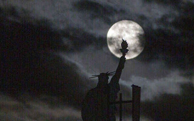 La super lune rose au dessus d'une réplique de la statue de la Liberté au kosovo, le 27 avril 2021. (Crédit : AP Photo/Visar Kryeziu) La super lune rose au dessus d'une réplique de la statue de la Liberté au kosovo, le 27 avril 2021. (Crédit : AP Photo/Visar Kryeziu)