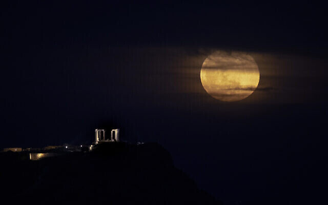 La super lune rose au dessus du temple de Poséidon au cap Sounion, en Grèce, le 17 avril 2021. (Crédit : AP Photo/Petros Giannakouris) La super lune rose au dessus du temple de Poséidon au cap Sounion, en Grèce, le 17 avril 2021. (Crédit : AP Photo/Petros Giannakouris)