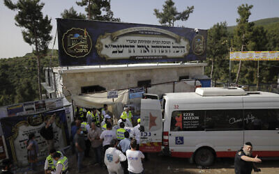Des responsables de la sécurité et les secours israéliens transportent les victimes mortes pendant les festivités de LagBomer sur le mont Meron, dans le nord d'Israël, le 30 avril 2021. (Crédit : AP Photo/Sebastian Scheiner)