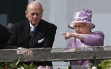 La reine Elizabeth II de Grande-Bretagne fait remarquer quelque chose au prince Philip alors qu'ils regardent le Derby d'Epsom depuis le balcon de l'hippodrome d'Epsom, en Angleterre, le 7 juin 2014. (AP Photo/Sang Tan)