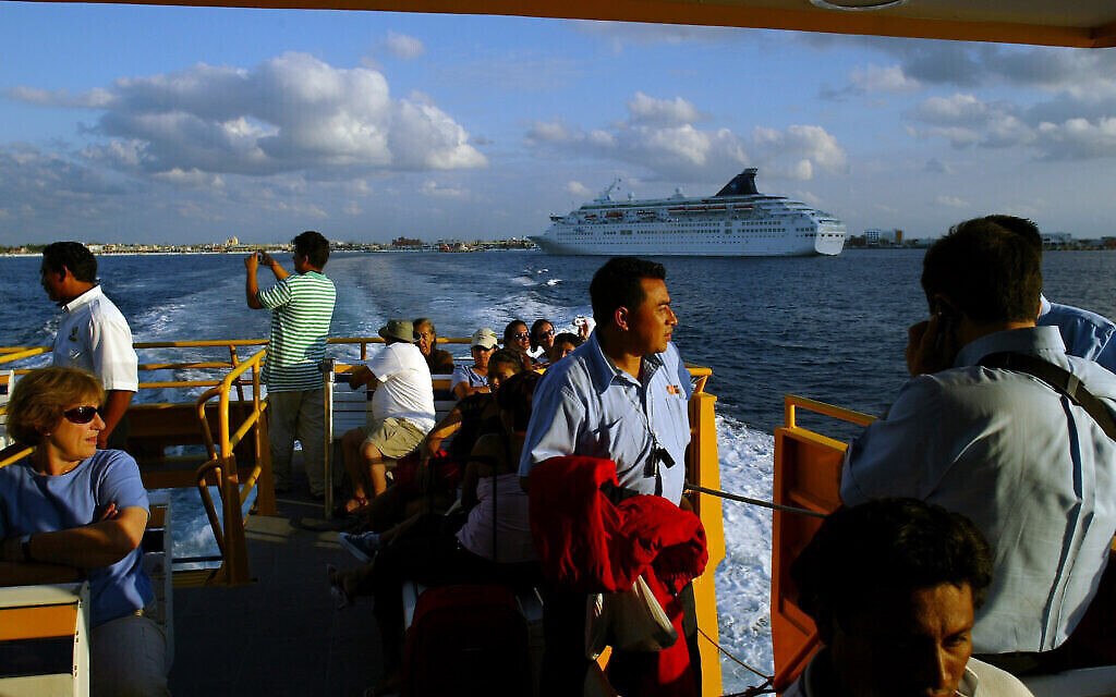 Illustration : Des touristes contemplent le paysage alors qu'ils retournent à Playa del Carmen après avoir visité l'île de Cozumel, au Mexique, le 14 décembre 2005. (AP Photo/Guillermo Arias)